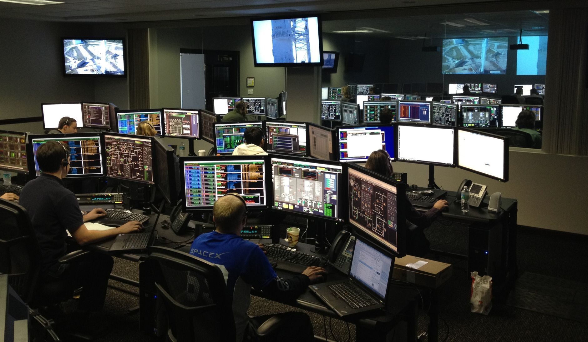 A busy control room with operators working at banks of monitors
