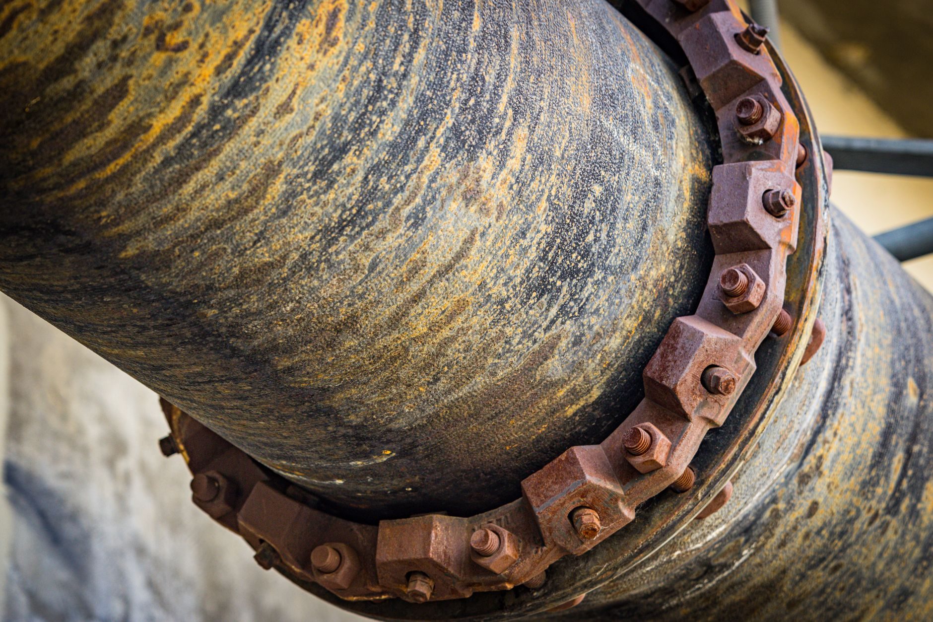 Close-up of a corroded steel pipe flange with rusted bolts